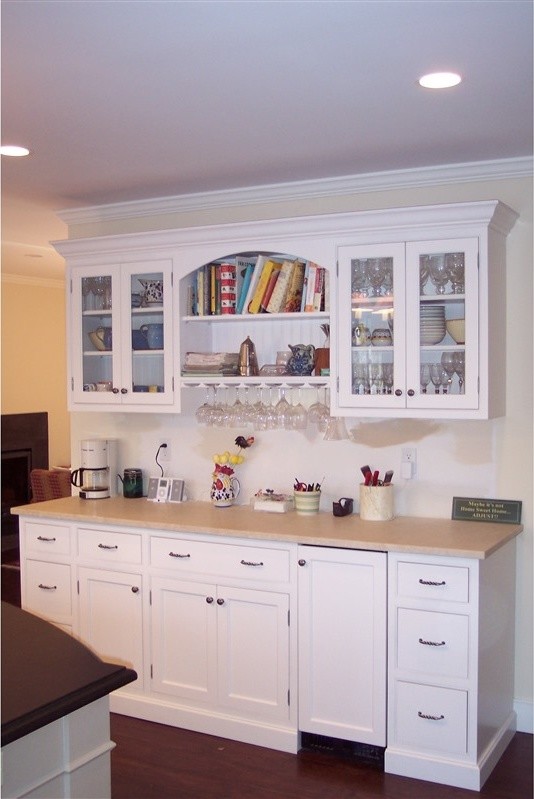 Bild på ett amerikanskt kök, med skåp i shakerstil, vita skåp, en undermonterad diskho, beige stänkskydd, rostfria vitvaror, mörkt trägolv och en köksö
