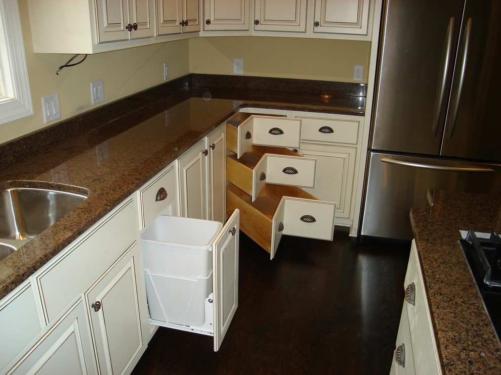 Bild på ett avskilt, stort funkis u-kök, med en trippel diskho, luckor med upphöjd panel, vita skåp, granitbänkskiva, brunt stänkskydd, stänkskydd i sten, rostfria vitvaror, mörkt trägolv och en köksö