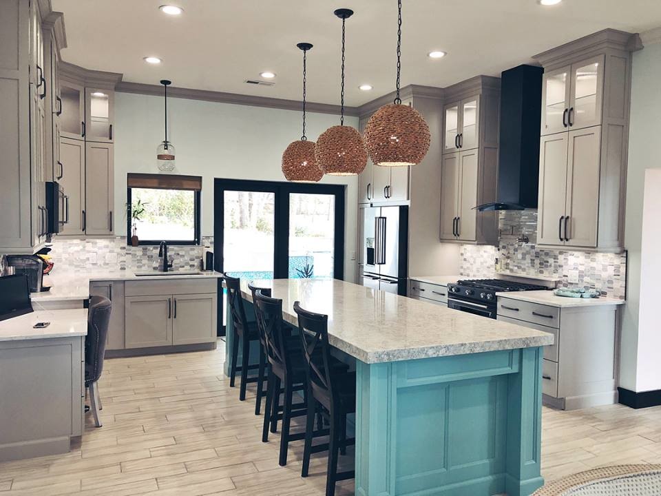Exempel på ett mellanstort modernt kök, med en undermonterad diskho, skåp i shakerstil, vita skåp, bänkskiva i kvartsit, beige stänkskydd, stänkskydd i marmor, rostfria vitvaror, laminatgolv, en köksö och brunt golv