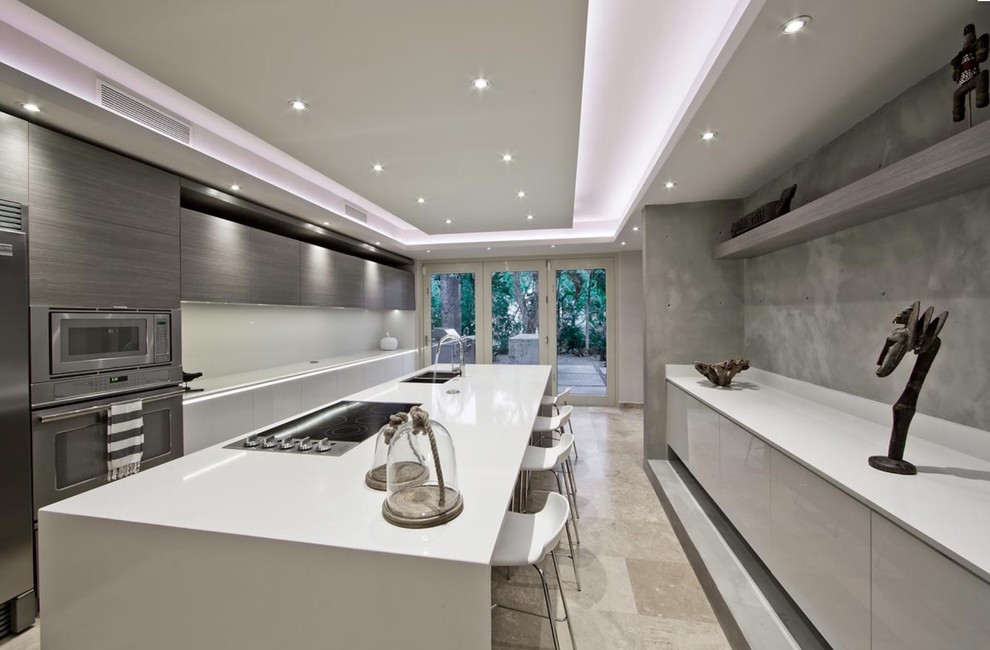 Exempel på ett stort modernt kök, med en dubbel diskho, släta luckor, vita skåp, bänkskiva i kvarts, vitt stänkskydd, rostfria vitvaror, marmorgolv och en köksö