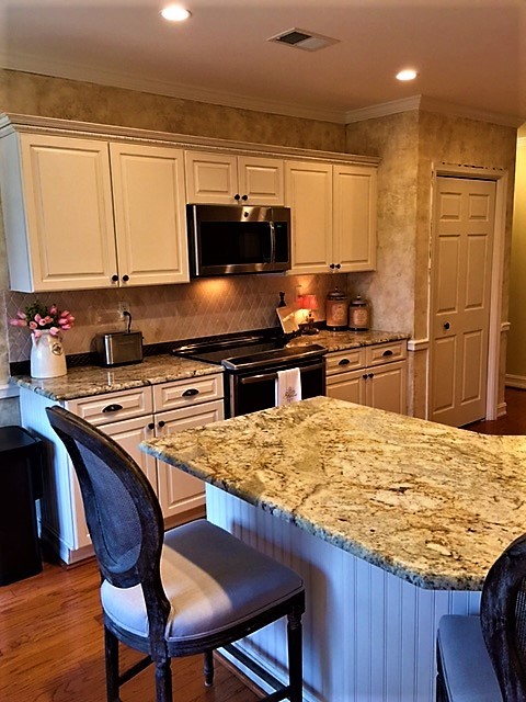 Foto di un cucina con isola centrale shabby-chic style con lavello da incasso, ante con riquadro incassato, ante bianche, top in marmo e elettrodomestici in acciaio inossidabile