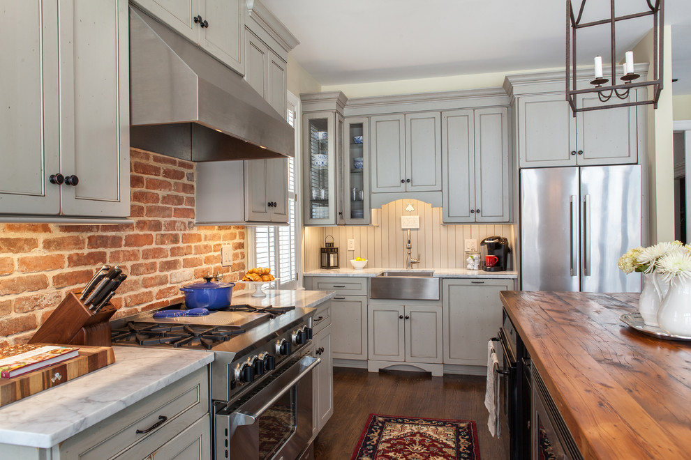 Exempel på ett mellanstort lantligt kök med öppen planlösning, med en rustik diskho, släta luckor, skåp i slitet trä, marmorbänkskiva, flerfärgad stänkskydd, rostfria vitvaror, mörkt trägolv och en köksö