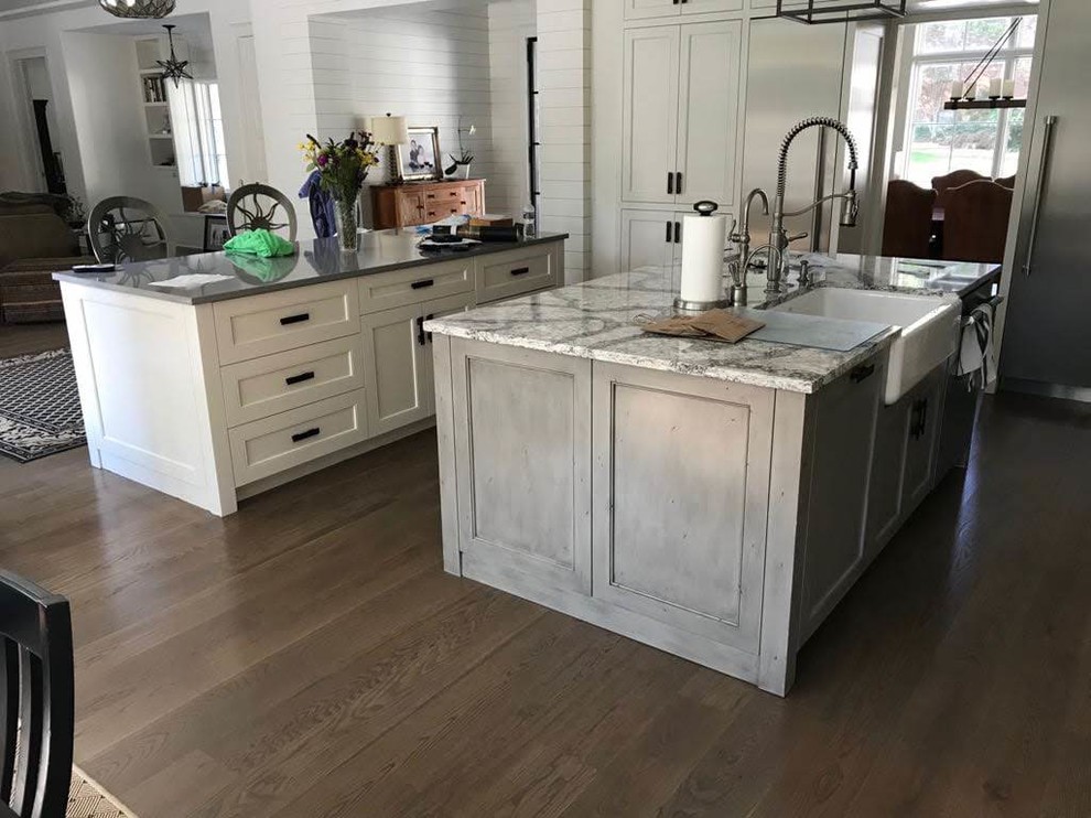 Inspiration for a large u-shaped medium tone wood floor and brown floor eat-in kitchen remodel in Atlanta with an undermount sink, shaker cabinets, white cabinets, quartzite countertops, gray backsplash, stone tile backsplash, stainless steel appliances, two islands and gray countertops