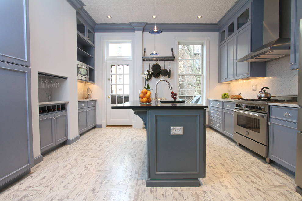 Klassische Küche mit Schrankfronten mit vertiefter Füllung, blauen Schränken, Küchenrückwand in Weiß und Küchengeräten aus Edelstahl in New York
