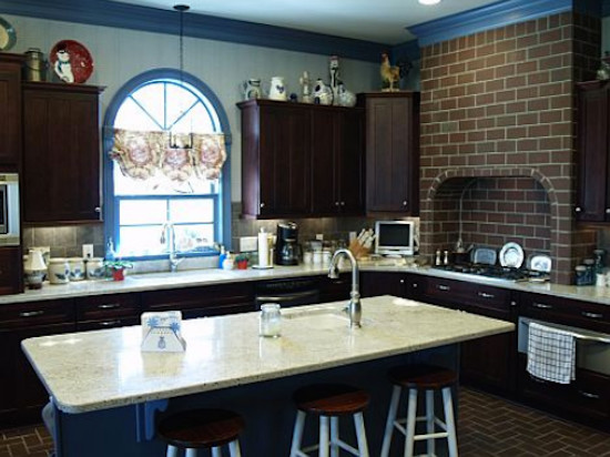Inredning av ett eklektiskt kök och matrum, med en undermonterad diskho, skåp i mörkt trä, granitbänkskiva, rostfria vitvaror, en köksö och tegelgolv