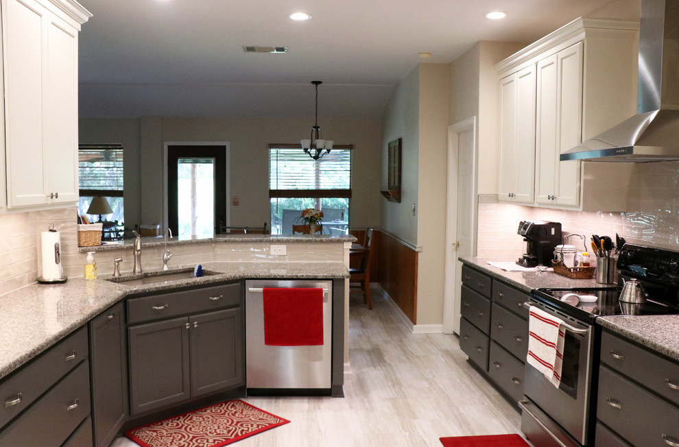 Foto på ett mellanstort vintage grå kök, med en undermonterad diskho, skåp i shakerstil, vita skåp, granitbänkskiva, vitt stänkskydd, stänkskydd i keramik, rostfria vitvaror, en köksö och beiget golv