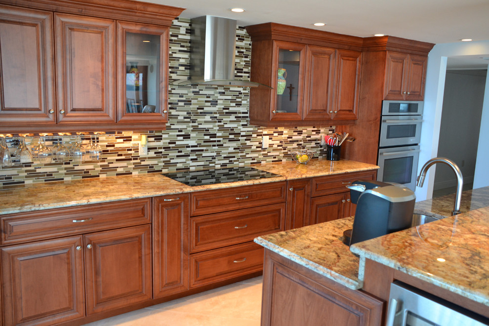 Exempel på ett mellanstort klassiskt brun linjärt brunt kök med öppen planlösning, med en undermonterad diskho, luckor med upphöjd panel, skåp i mellenmörkt trä, granitbänkskiva, grått stänkskydd, stänkskydd i stickkakel, rostfria vitvaror, en köksö och beiget golv