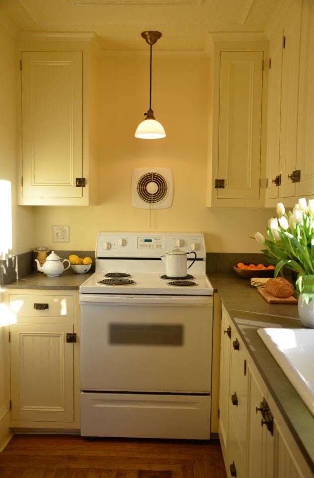 Esempio di una cucina tradizionale di medie dimensioni con lavello stile country, ante a filo, ante bianche, top in superficie solida, paraspruzzi bianco e elettrodomestici bianchi