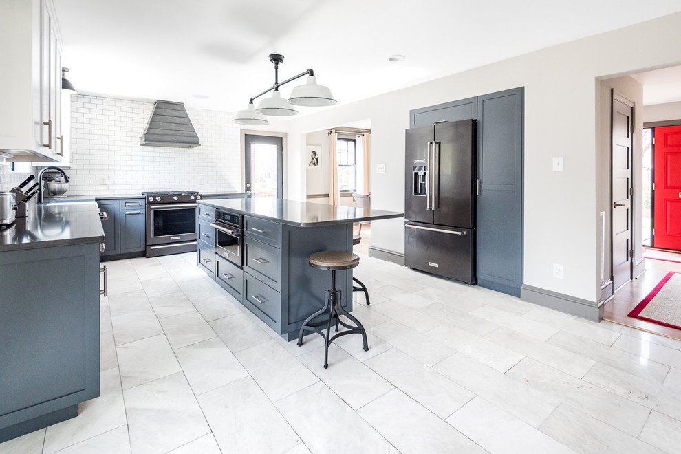 Inspiration for a large country l-shaped marble floor and gray floor enclosed kitchen remodel in Wilmington with a farmhouse sink, shaker cabinets, blue cabinets, quartz countertops, white backsplash, subway tile backsplash, black appliances, an island and black countertops