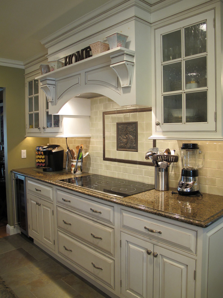 Inredning av ett klassiskt kök, med luckor med upphöjd panel, vita skåp, granitbänkskiva, beige stänkskydd, stänkskydd i travertin, skiffergolv och beiget golv