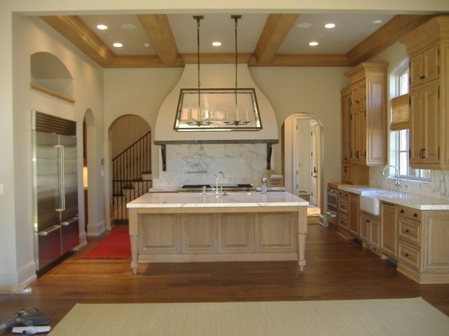 Example of a large classic u-shaped dark wood floor and brown floor eat-in kitchen design in Indianapolis with a farmhouse sink, raised-panel cabinets, light wood cabinets, marble countertops, stainless steel appliances, white backsplash, stone slab backsplash and an island