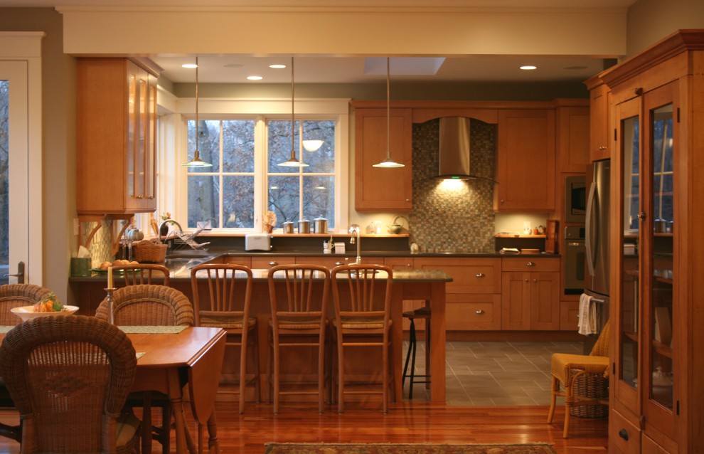 Eat-in kitchen - traditional u-shaped eat-in kitchen idea in Chicago with shaker cabinets, medium tone wood cabinets, multicolored backsplash and stainless steel appliances