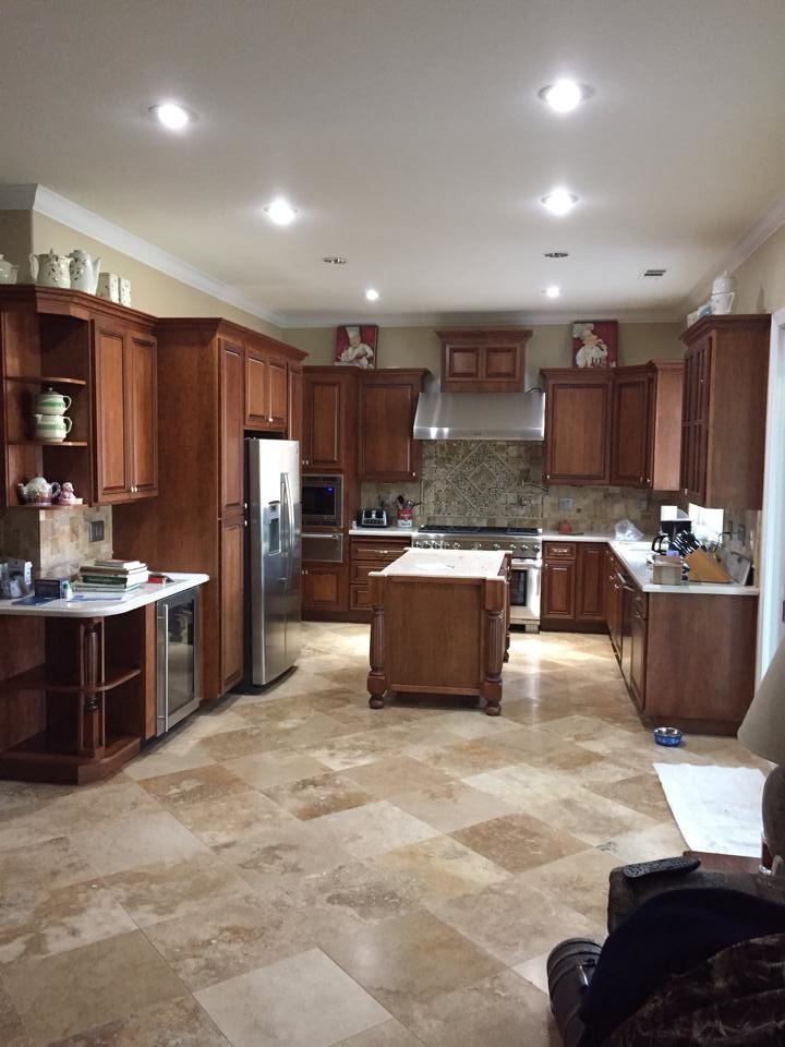 This is an example of a large classic kitchen in Sacramento with raised-panel cabinets, dark wood cabinets, limestone flooring and an island.