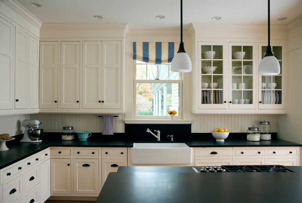 Klassische Küche mit Landhausspüle, Kassettenfronten, weißen Schränken, Granit-Arbeitsplatte, Küchenrückwand in Weiß, Küchengeräten aus Edelstahl, braunem Holzboden und Kücheninsel in Boston