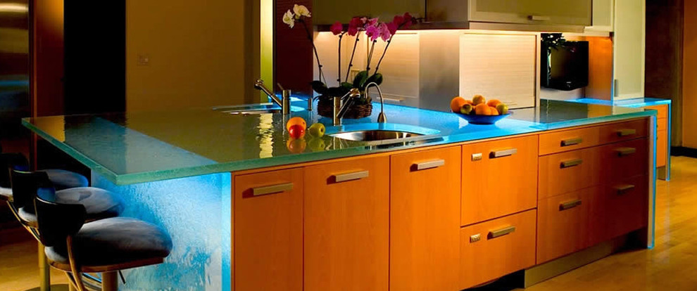 Ispirazione per una grande cucina moderna con lavello sottopiano, ante lisce, ante in legno scuro, top in vetro e parquet chiaro