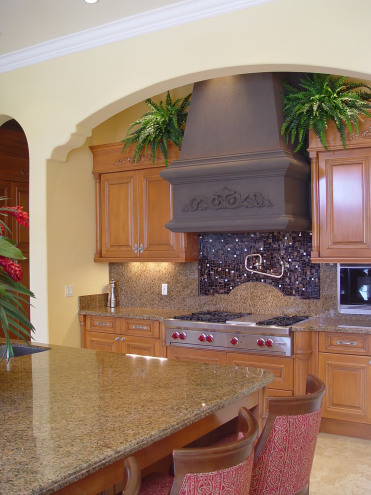 Bild på ett medelhavsstil kök, med luckor med upphöjd panel, skåp i mellenmörkt trä, brunt stänkskydd och rostfria vitvaror