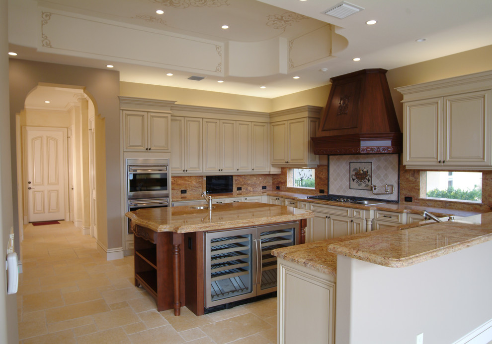 Bild på ett medelhavsstil kök, med rostfria vitvaror, granitbänkskiva, luckor med upphöjd panel, beige skåp och flerfärgad stänkskydd