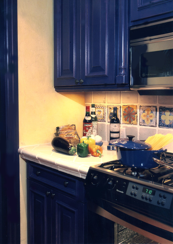 Tuscan kitchen photo in Other with raised-panel cabinets, blue cabinets, tile countertops and multicolored backsplash