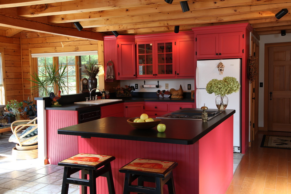 Inredning av ett rustikt mellanstort kök, med en integrerad diskho, luckor med infälld panel, röda skåp, bänkskiva i koppar, vita vitvaror, klinkergolv i keramik och en halv köksö