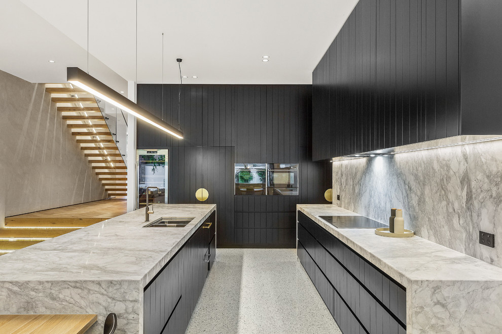 Example of a large trendy l-shaped concrete floor and white floor open concept kitchen design in Melbourne with an undermount sink, black cabinets, marble countertops, gray backsplash, marble backsplash, black appliances, an island and gray countertops