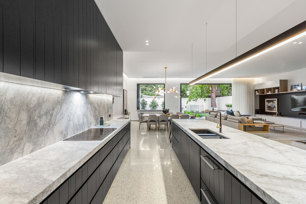 Photo of a large contemporary galley open plan kitchen in Melbourne with a submerged sink, black cabinets, marble worktops, grey splashback, marble splashback, black appliances, concrete flooring, an island, grey floors and grey worktops.