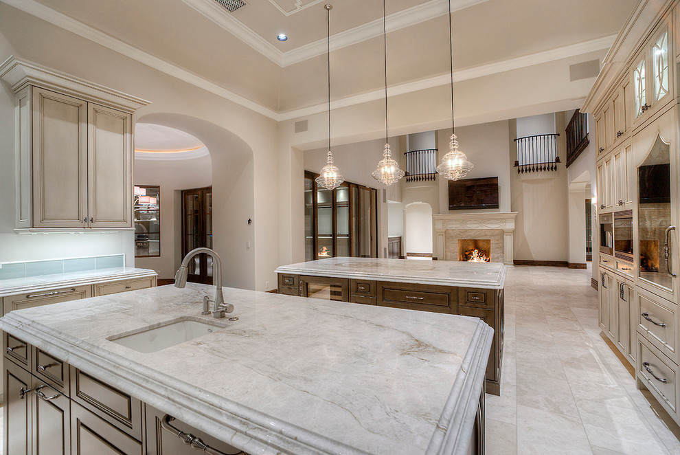 Example of a huge transitional u-shaped medium tone wood floor enclosed kitchen design in Phoenix with a farmhouse sink, granite countertops, stainless steel appliances, glass-front cabinets, medium tone wood cabinets, beige backsplash, mosaic tile backsplash and two islands