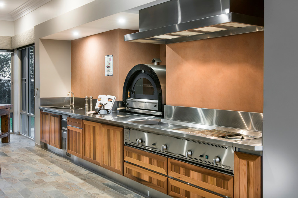 パースにあるラグジュアリーなカントリー風のおしゃれな独立型キッチン (中間色木目調キャビネット、ステンレスカウンター、シルバーの調理設備、アイランドなし) の写真