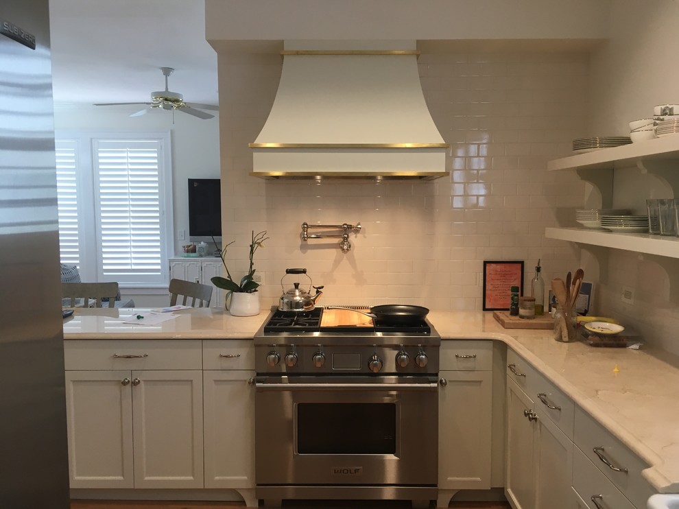 Enclosed kitchen - mid-sized transitional l-shaped enclosed kitchen idea in Tampa with shaker cabinets, white cabinets, marble countertops, white backsplash, subway tile backsplash, stainless steel appliances, a peninsula and white countertops