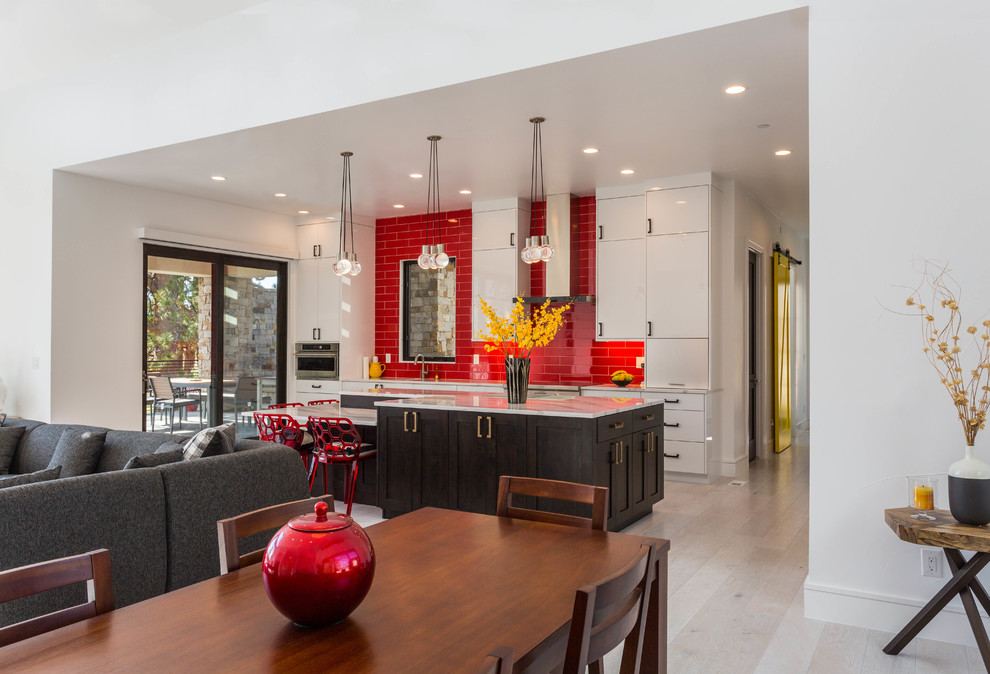 Expansive contemporary galley open plan kitchen in Denver with a submerged sink, flat-panel cabinets, white cabinets, quartz worktops, red splashback, metro tiled splashback, stainless steel appliances, multiple islands and white worktops.