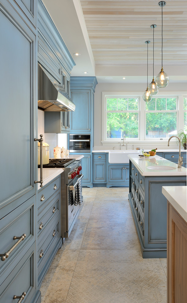 Bild på ett stort vintage kök, med luckor med infälld panel, blå skåp, bänkskiva i kvartsit, en köksö, en rustik diskho, vitt stänkskydd, rostfria vitvaror, klinkergolv i keramik och beiget golv