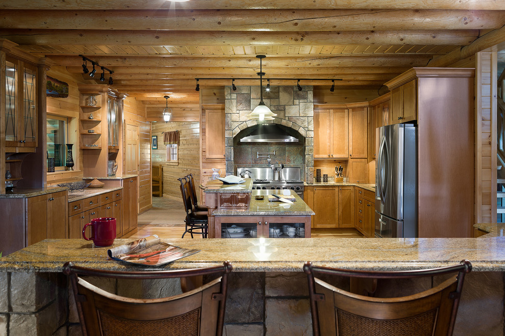 Immagine di una cucina ad U stile rurale con ante con riquadro incassato, ante in legno scuro, top in granito e elettrodomestici in acciaio inossidabile