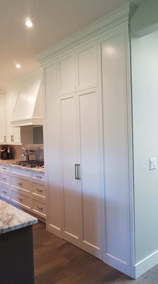 Photo of a large traditional l-shaped kitchen/diner in Vancouver with shaker cabinets, white cabinets, granite worktops, brown worktops, a submerged sink, grey splashback, ceramic splashback, stainless steel appliances, medium hardwood flooring, an island and brown floors.
