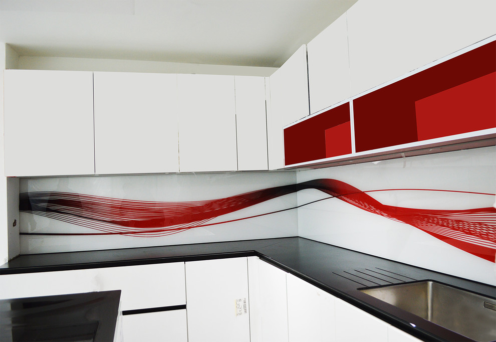 Immagine di una grande cucina minimalista con ante lisce, ante bianche, top in marmo, paraspruzzi rosso e paraspruzzi con lastra di vetro