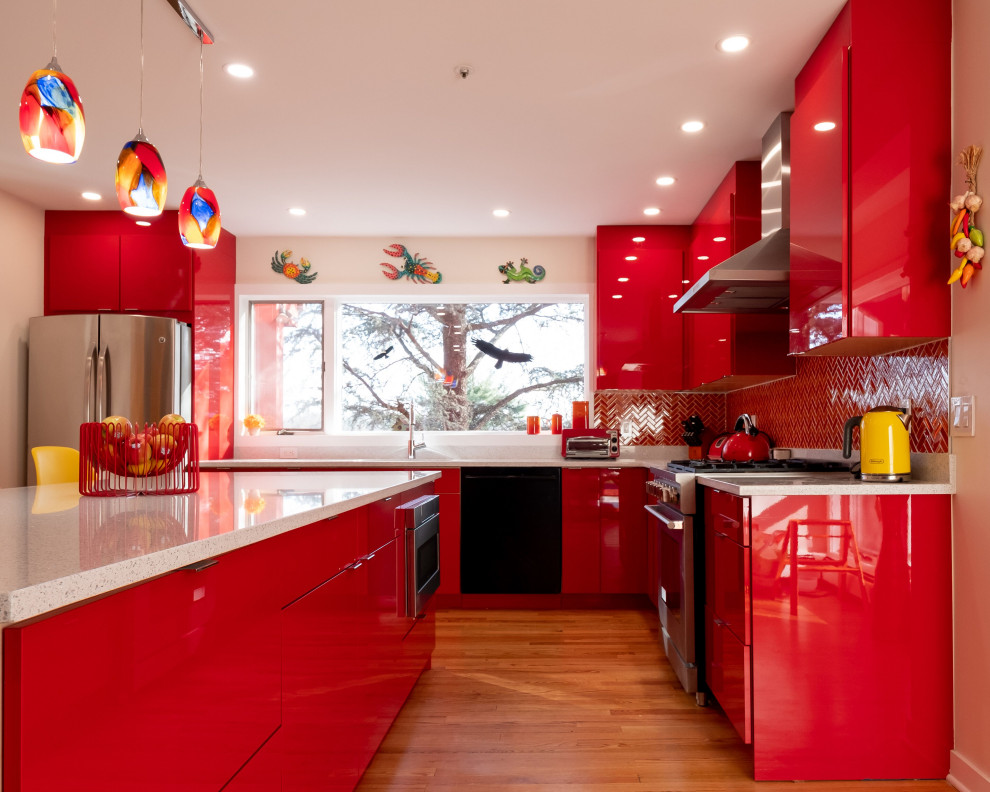 Photo of a medium sized bohemian l-shaped kitchen/diner in New York with a submerged sink, flat-panel cabinets, red cabinets, engineered stone countertops, multi-coloured splashback, ceramic splashback, stainless steel appliances, light hardwood flooring, an island, brown floors and white worktops.