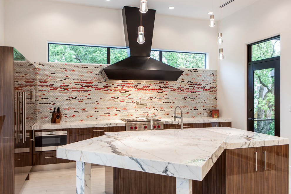 Moderne Küche mit Kücheninsel, flächenbündigen Schrankfronten, hellbraunen Holzschränken, bunter Rückwand, Rückwand aus Mosaikfliesen und Küchengeräten aus Edelstahl in Houston