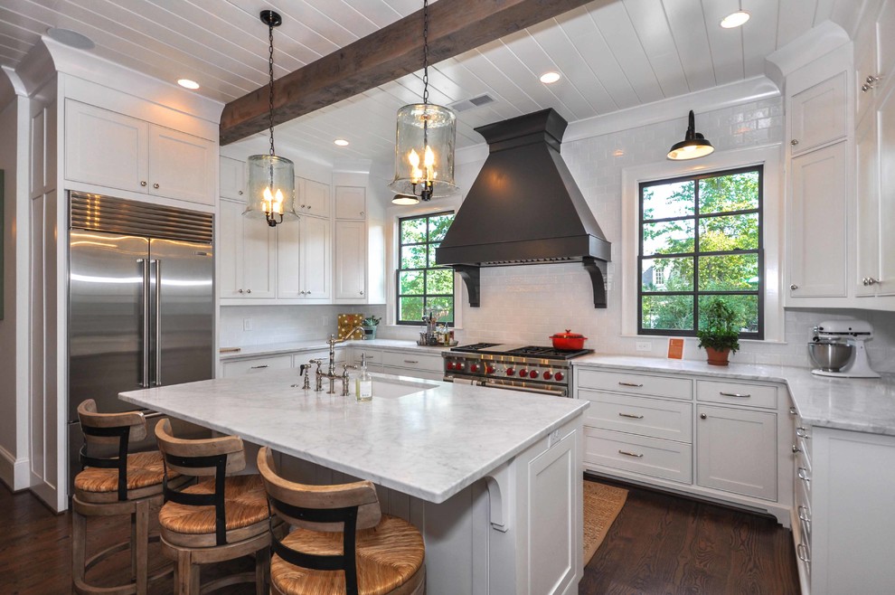 Photo of a traditional u-shaped kitchen in Atlanta with a submerged sink, beaded cabinets, white cabinets, white splashback, stainless steel appliances, dark hardwood flooring and an island.