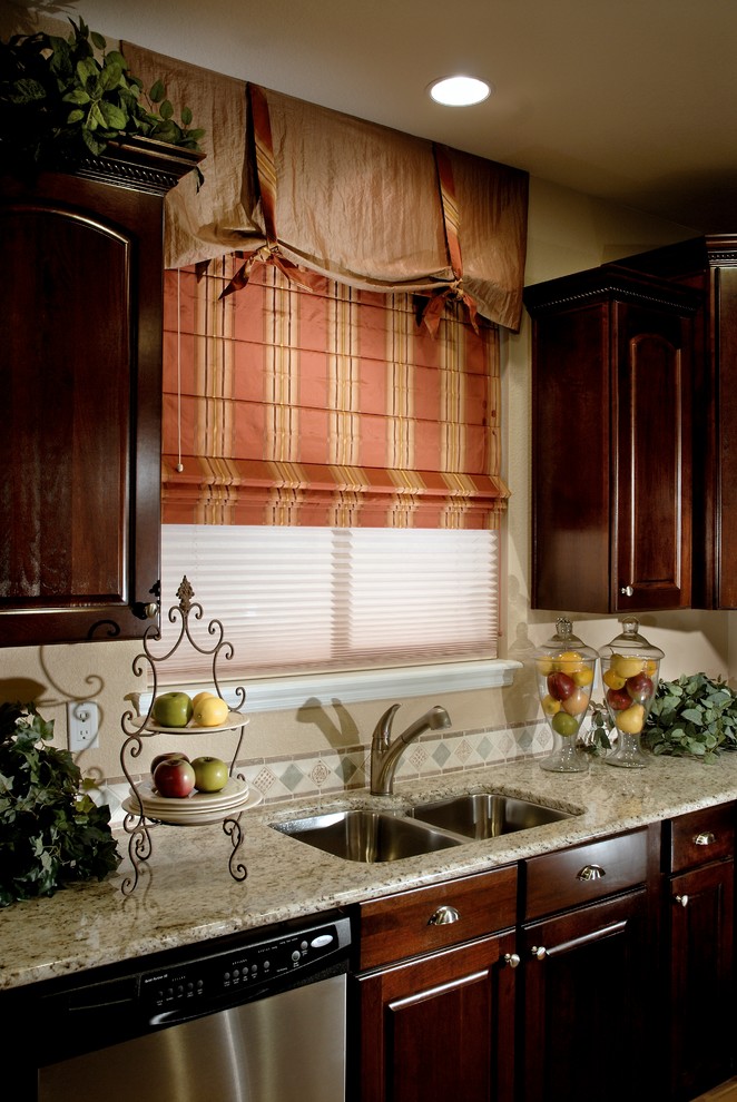 Foto di una cucina tradizionale di medie dimensioni con lavello sottopiano, ante con bugna sagomata, ante in legno bruno, top in marmo e paraspruzzi con piastrelle a mosaico