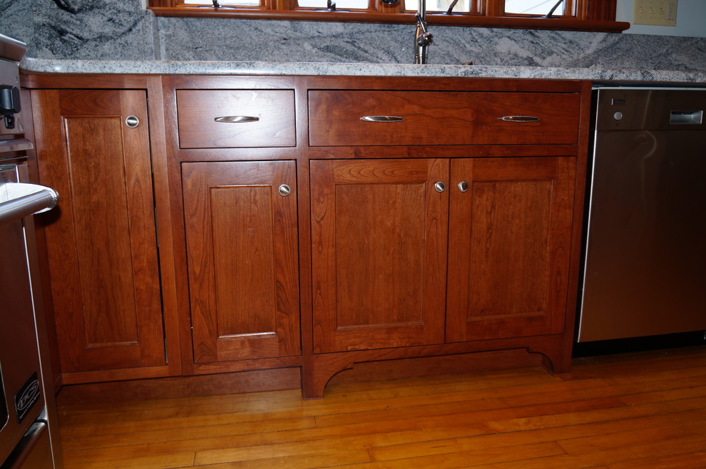 Exempel på ett amerikanskt kök, med en undermonterad diskho, skåp i shakerstil, skåp i mellenmörkt trä, träbänkskiva, grått stänkskydd, stänkskydd i sten, rostfria vitvaror, ljust trägolv och en köksö