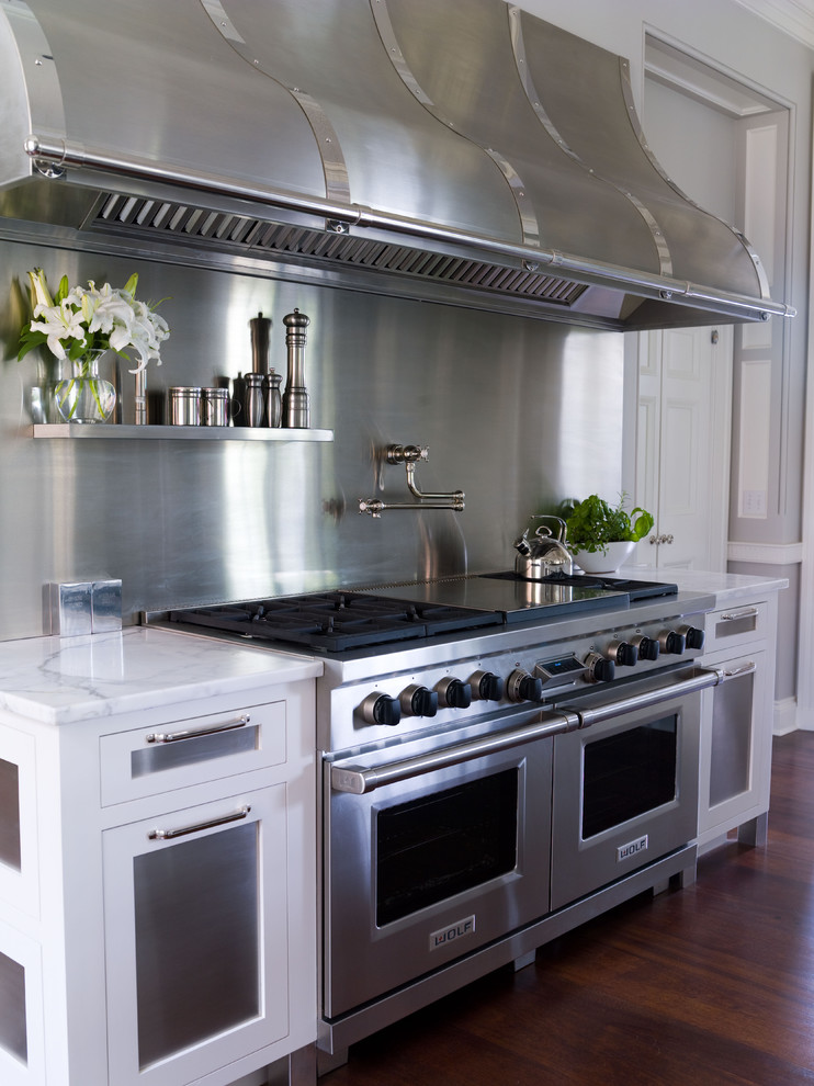 Traditional kitchen in New York with stainless steel appliances, marble worktops, metallic splashback and metal splashback.