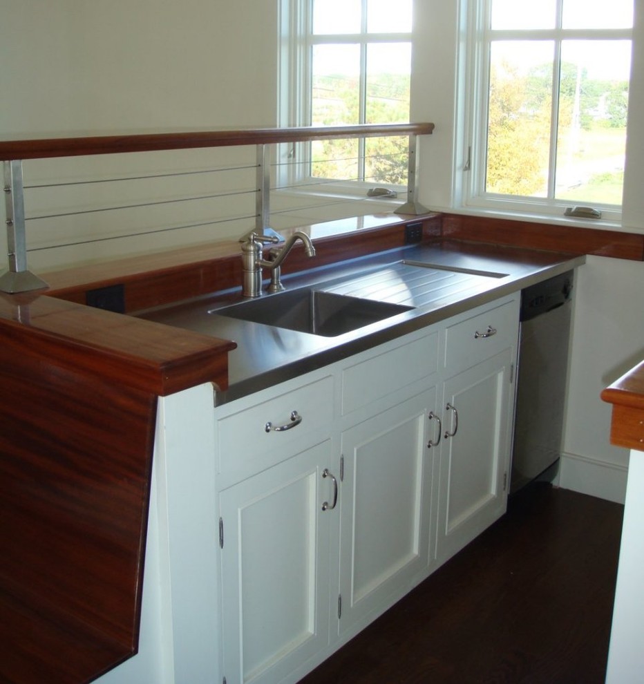 Zweizeilige Maritime Küche mit integriertem Waschbecken, weißen Schränken, Edelstahl-Arbeitsplatte und Küchengeräten aus Edelstahl in Portland Maine