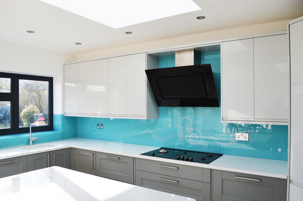Design ideas for a large modern kitchen/diner in Hertfordshire with flat-panel cabinets, white cabinets, marble worktops, blue splashback, glass sheet splashback and an island.