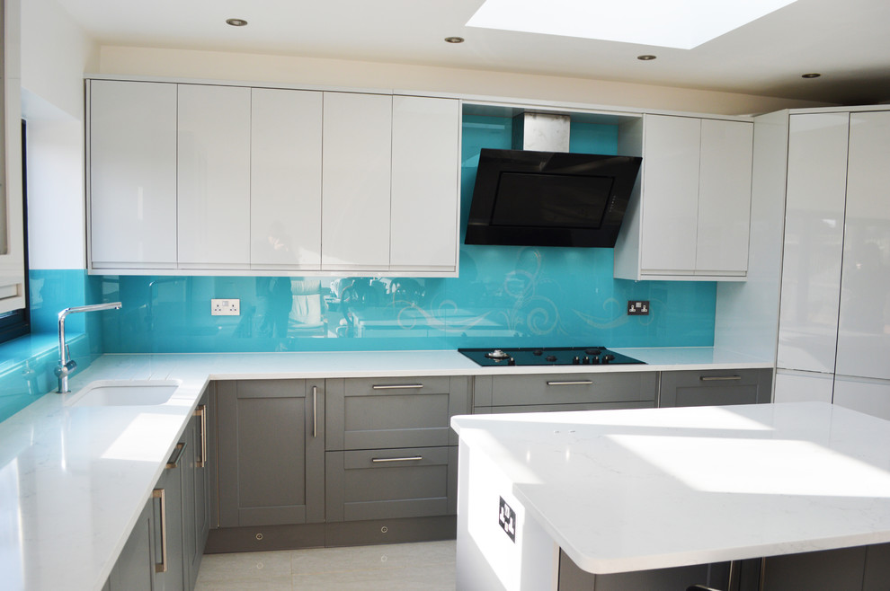 Design ideas for a large modern kitchen/diner in Hertfordshire with flat-panel cabinets, white cabinets, marble worktops, blue splashback, glass sheet splashback and an island.