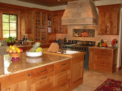 Inredning av ett rustikt stort kök och matrum, med en rustik diskho, luckor med upphöjd panel, skåp i mellenmörkt trä, granitbänkskiva, beige stänkskydd, stänkskydd i stenkakel, rostfria vitvaror, travertin golv och en köksö