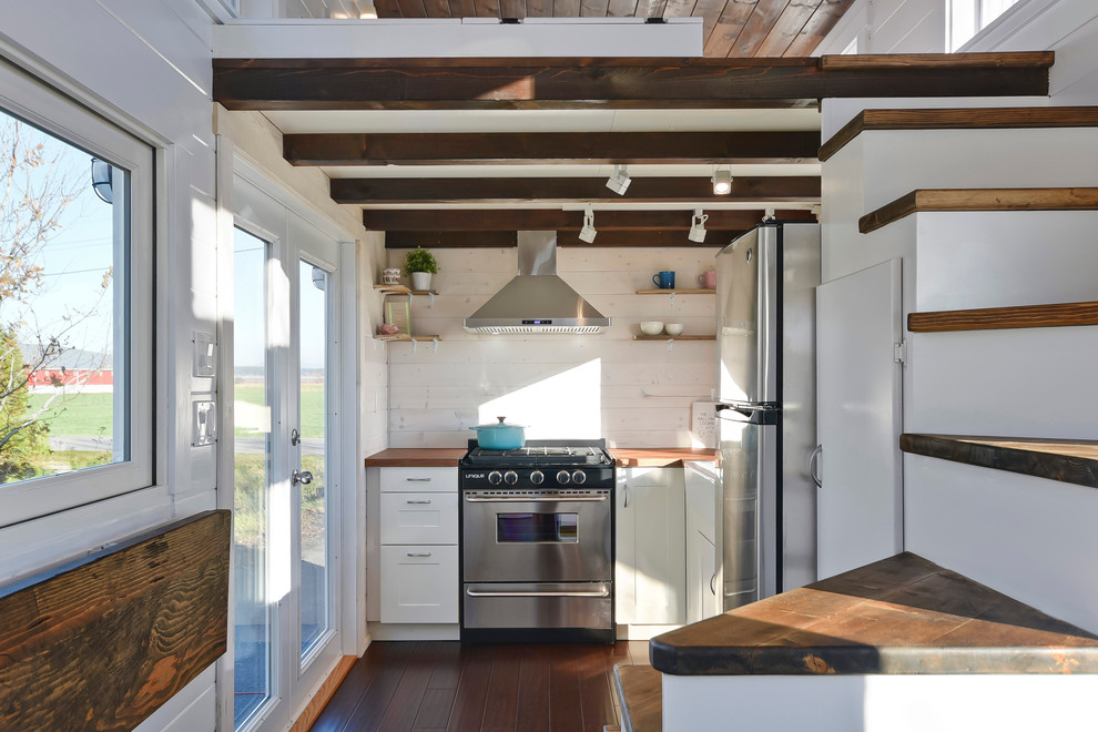 Kleine Landhaus Küche mit Landhausspüle, weißen Schränken, Arbeitsplatte aus Holz, Küchengeräten aus Edelstahl und dunklem Holzboden in Vancouver