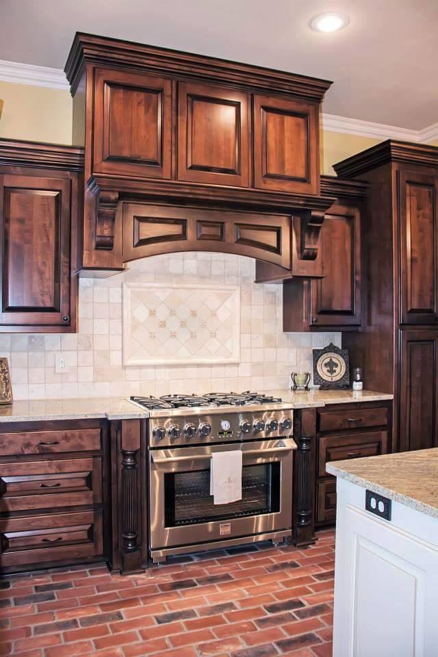 Cette image montre une cuisine américaine chalet en L de taille moyenne avec une crédence beige, une crédence en carrelage de pierre et un sol en brique.