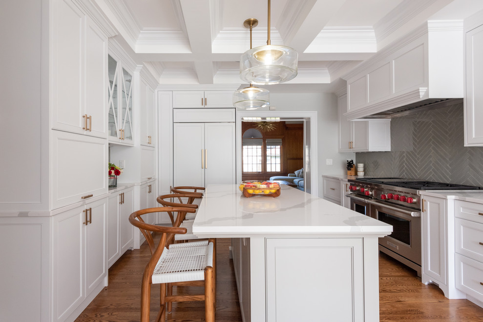 Large beach style u-shaped medium tone wood floor enclosed kitchen photo in Providence with shaker cabinets, white cabinets, quartz countertops, paneled appliances, an island, white countertops and gray backsplash