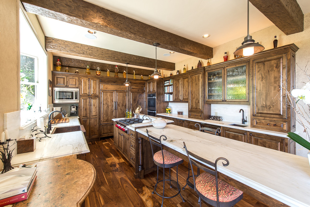 Inspiration för ett stort rustikt kök, med en rustik diskho, luckor med upphöjd panel, skåp i mörkt trä, marmorbänkskiva, integrerade vitvaror, mörkt trägolv, en köksö, brunt golv, vitt stänkskydd och stänkskydd i sten