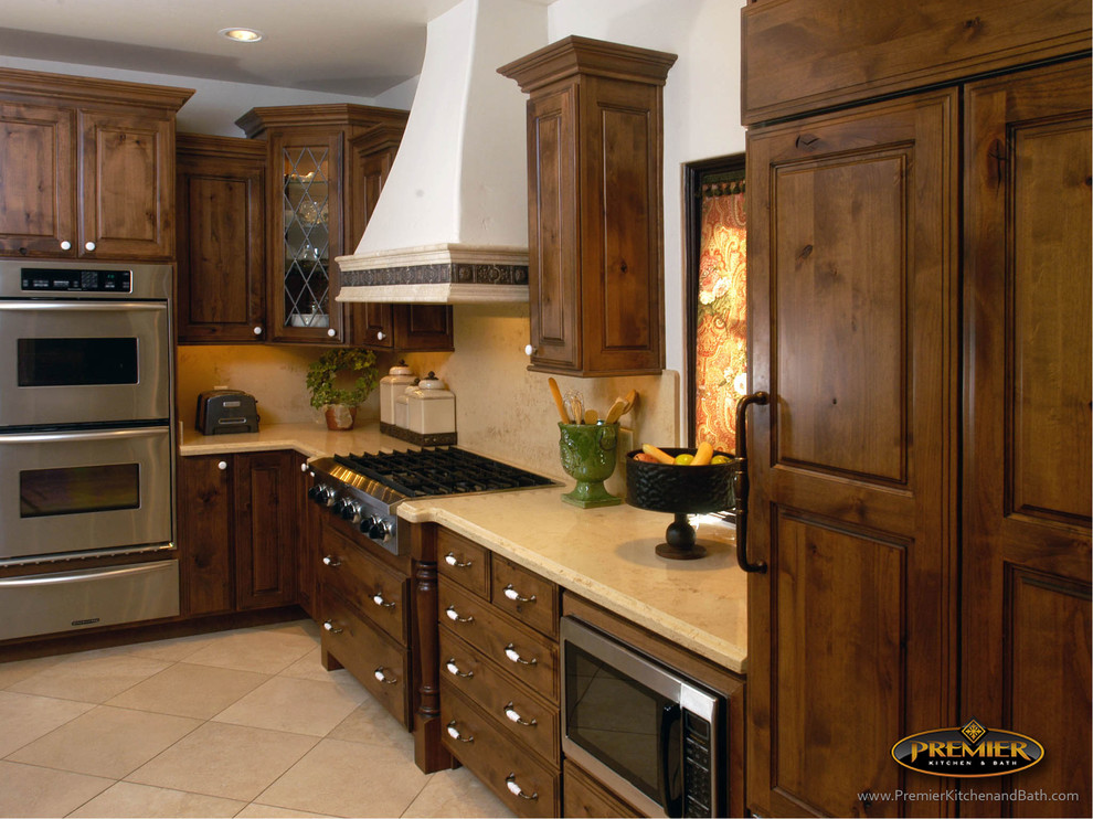 Klassisk inredning av ett stort kök, med luckor med upphöjd panel, skåp i mellenmörkt trä, laminatbänkskiva, beige stänkskydd, rostfria vitvaror och klinkergolv i porslin