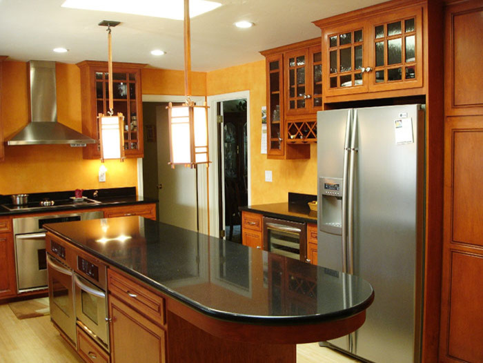 Photo of a medium sized traditional l-shaped enclosed kitchen in Cleveland with raised-panel cabinets, medium wood cabinets, composite countertops, yellow splashback, stainless steel appliances, vinyl flooring and an island.