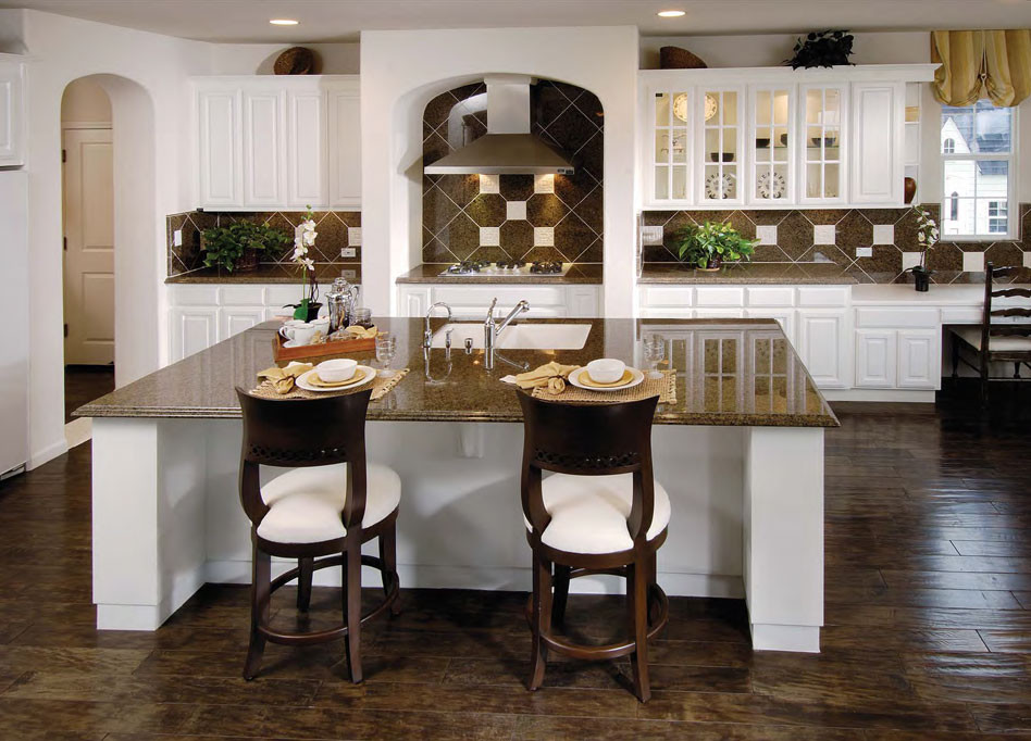 Inredning av ett medelhavsstil stort linjärt kök med öppen planlösning, med en dubbel diskho, luckor med upphöjd panel, vita skåp, granitbänkskiva, brunt stänkskydd, stänkskydd i keramik, rostfria vitvaror, mörkt trägolv och en köksö